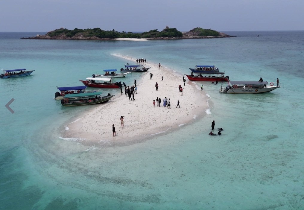 Pandangan dron beting pasir Little Maldives Pulau Redang dengan lebih sepuluh bot pelancong berlabuh pada satu masa
