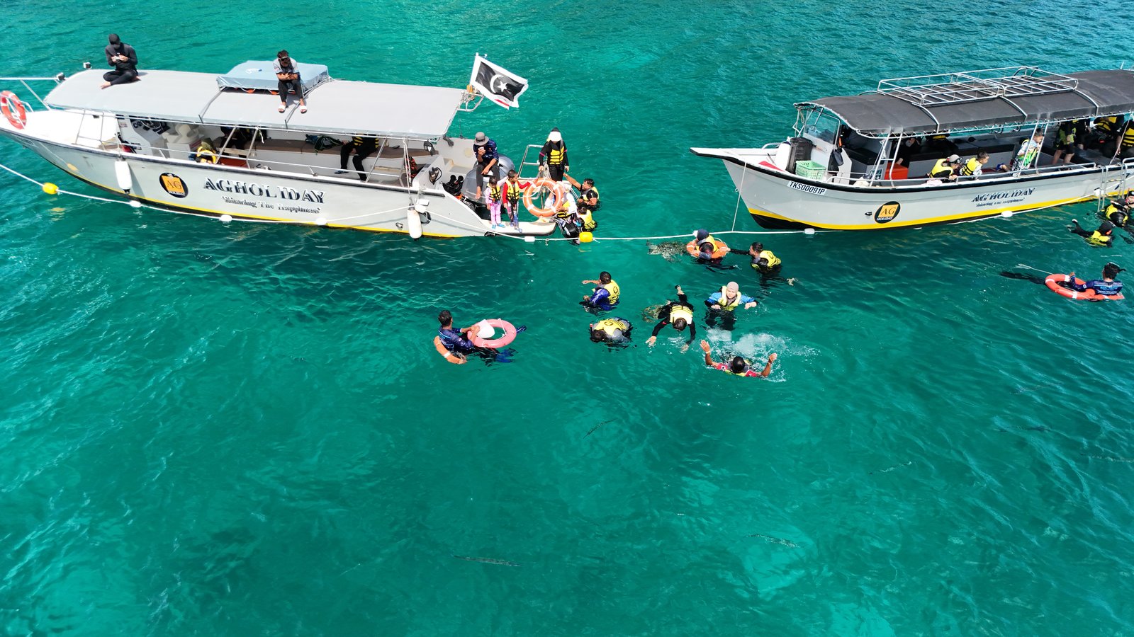 Dua bot AG Holiday berlabuh dengan peserta snorkeling di atas karang dalam kawasan taman laut Pulau Redang